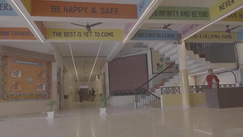 Spacious atrium hall with a mural and staircase