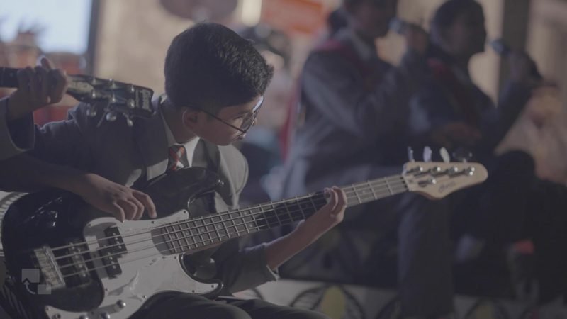 Students playing guitar and drums in the school band