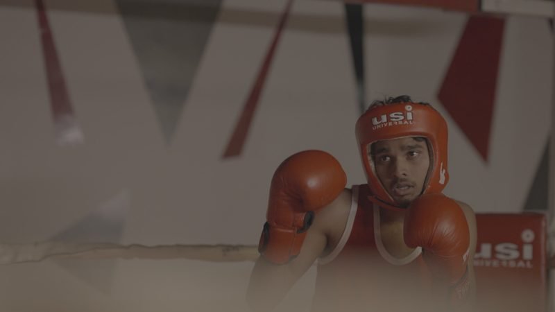 Student in boxing headgear and gloves at training