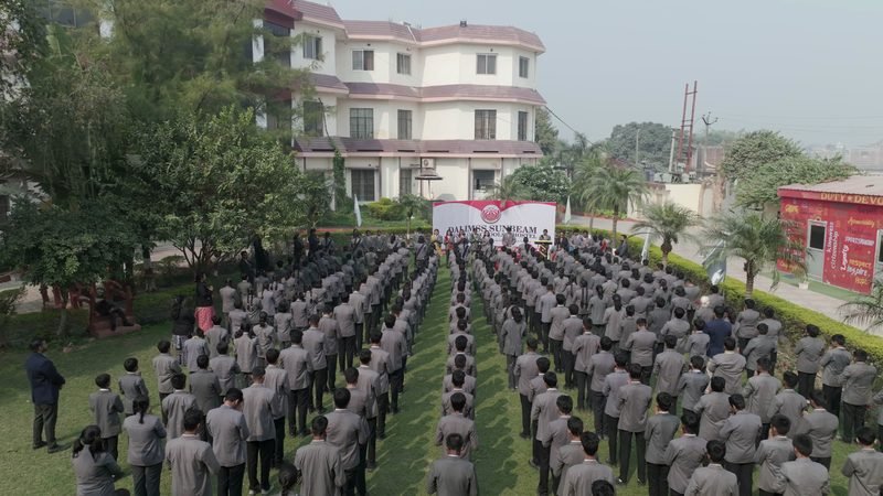 Students at morning assembly on the lawn, seen from the air at Dalimss Sunbeam Rohania