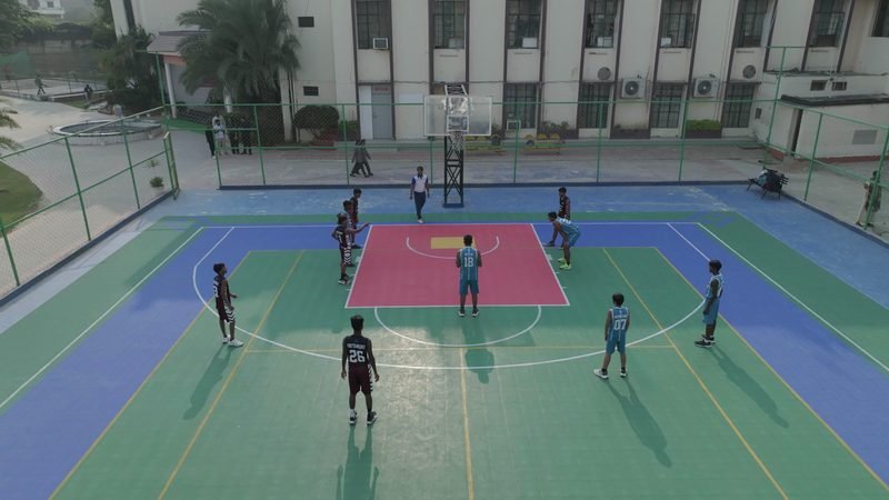 Students playing basketball, seen from the air, Rohania