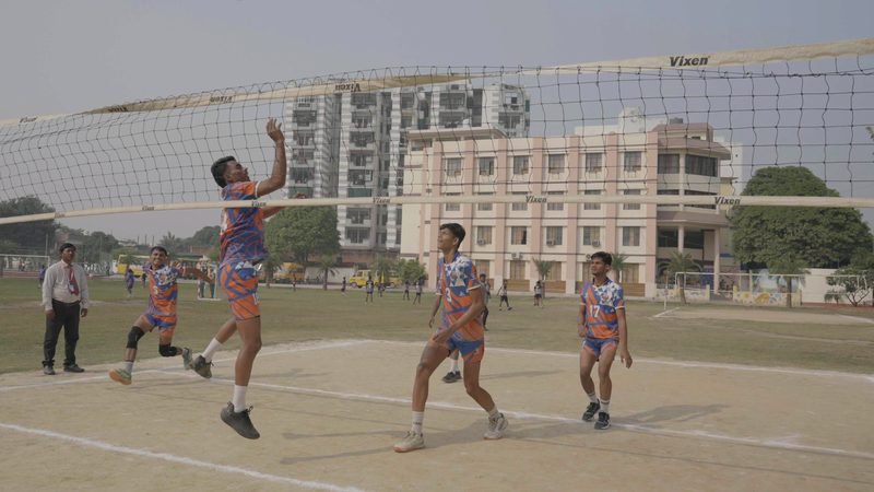 Students playing volleyball on the outdoor court, Rohania