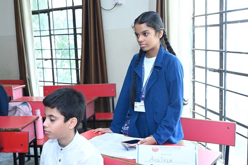 A student delegate speaks from her desk during a Model UN committee session