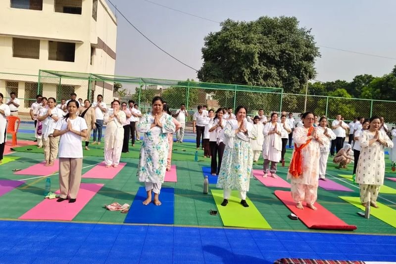 Students and teachers practising yoga on the school court, Rohania